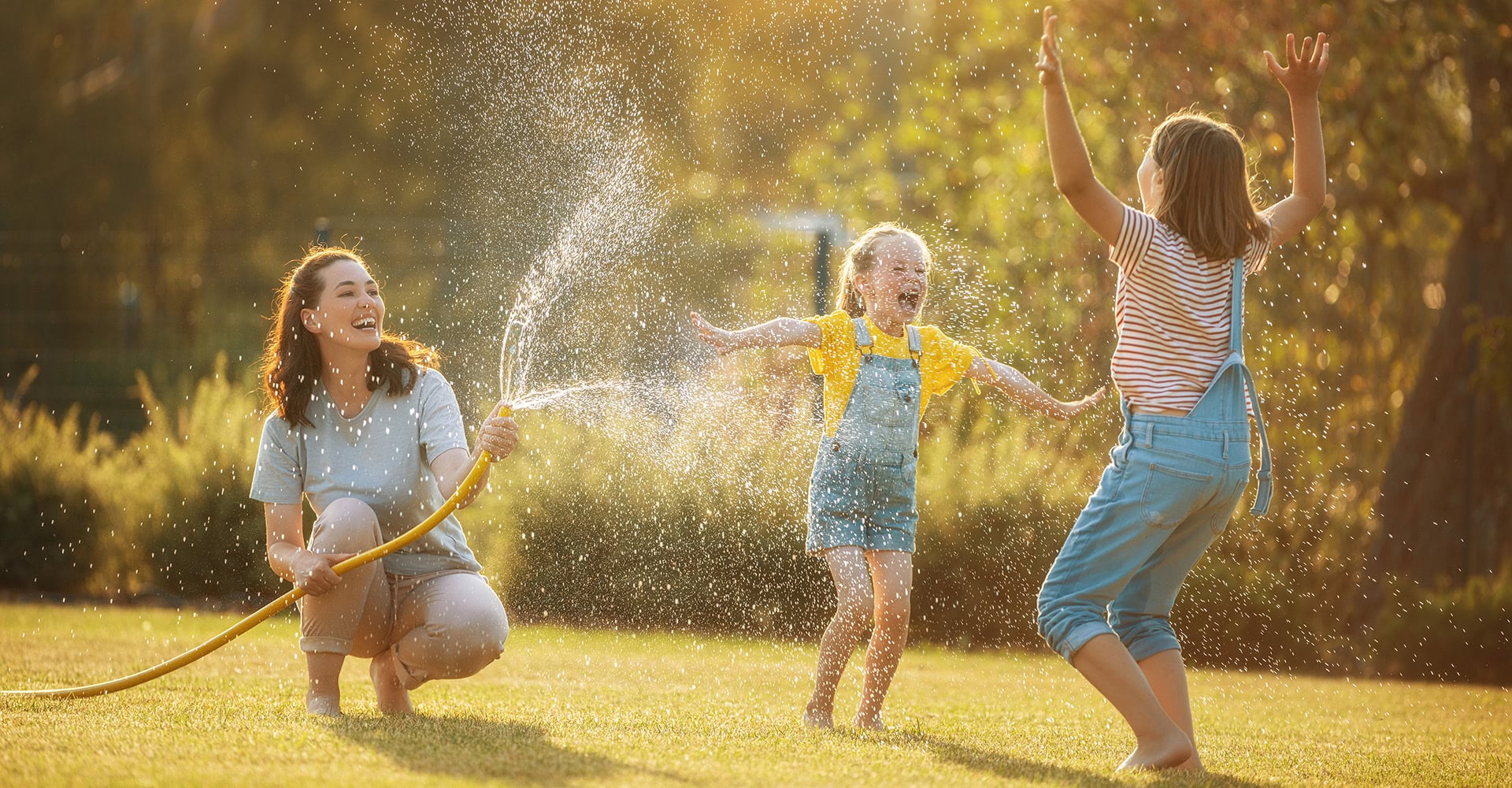 A mom and daughters playing in a hose.
